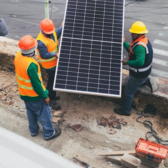 Solar Technicians Carrying Solar Panel